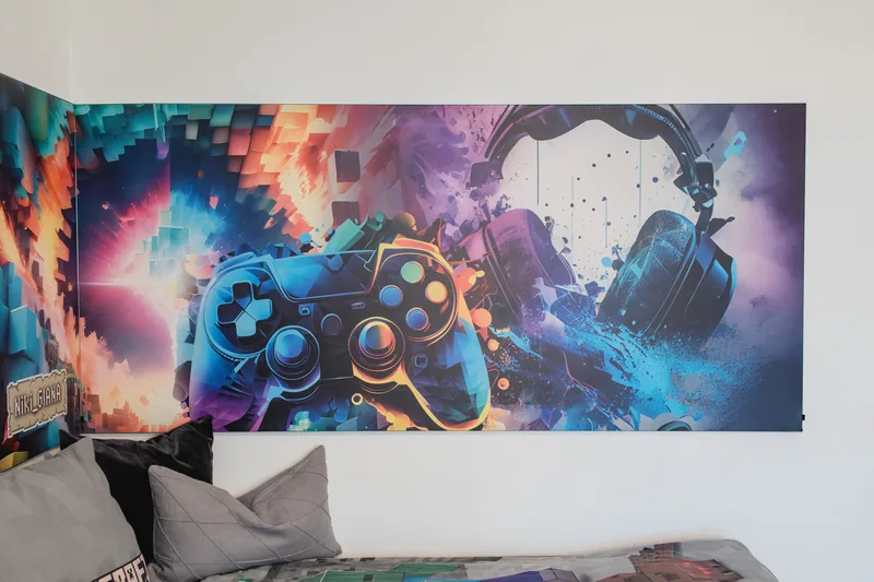 Jugendzimmer mit textiler Wandfläche und Gaming-Motiv über dem Bett